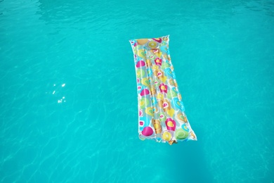 Photo of Colorful inflatable mattress floating in swimming pool on sunny day. Space for text