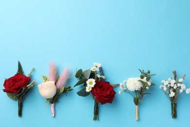 Photo of Many stylish boutonnieres on light blue background, flat lay. Space for text