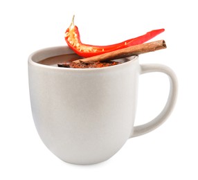 Photo of Cup of hot chocolate with chili pepper and cinnamon on white background