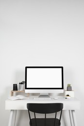 Photo of Cozy workspace with laptop, houseplant and stationery on wooden desk at home
