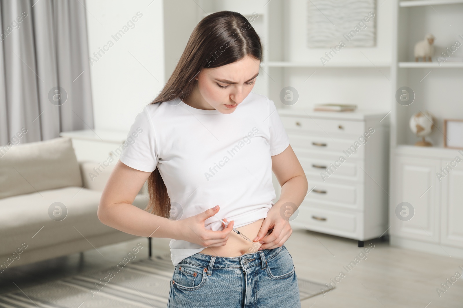 Photo of Diabetes. Woman making insulin injection into her belly at home