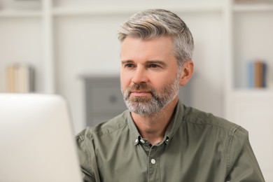 Photo of Professional accountant using computer while working in office