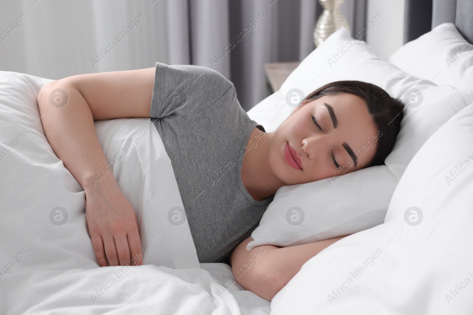 Photo of Beautiful young woman sleeping in soft bed at home