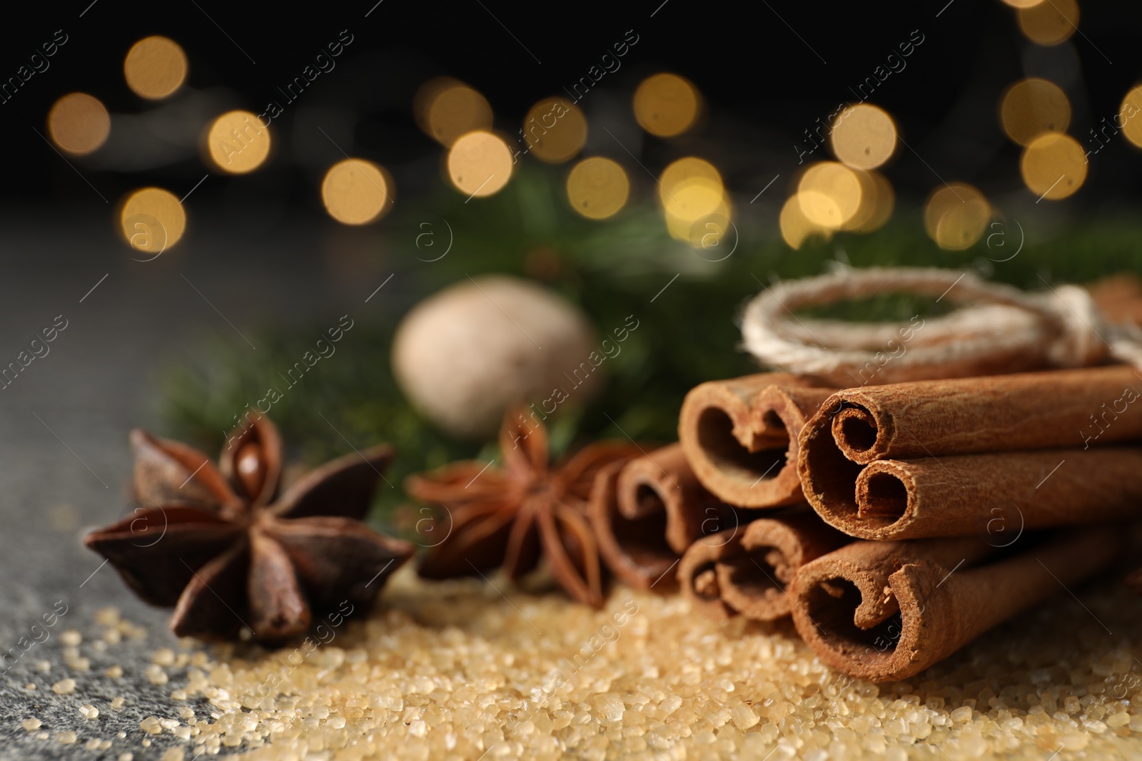 Photo of Different spices on table against blurred lights, closeup