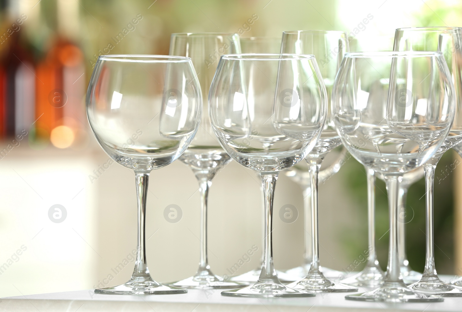 Photo of Empty glasses on table against blurred background