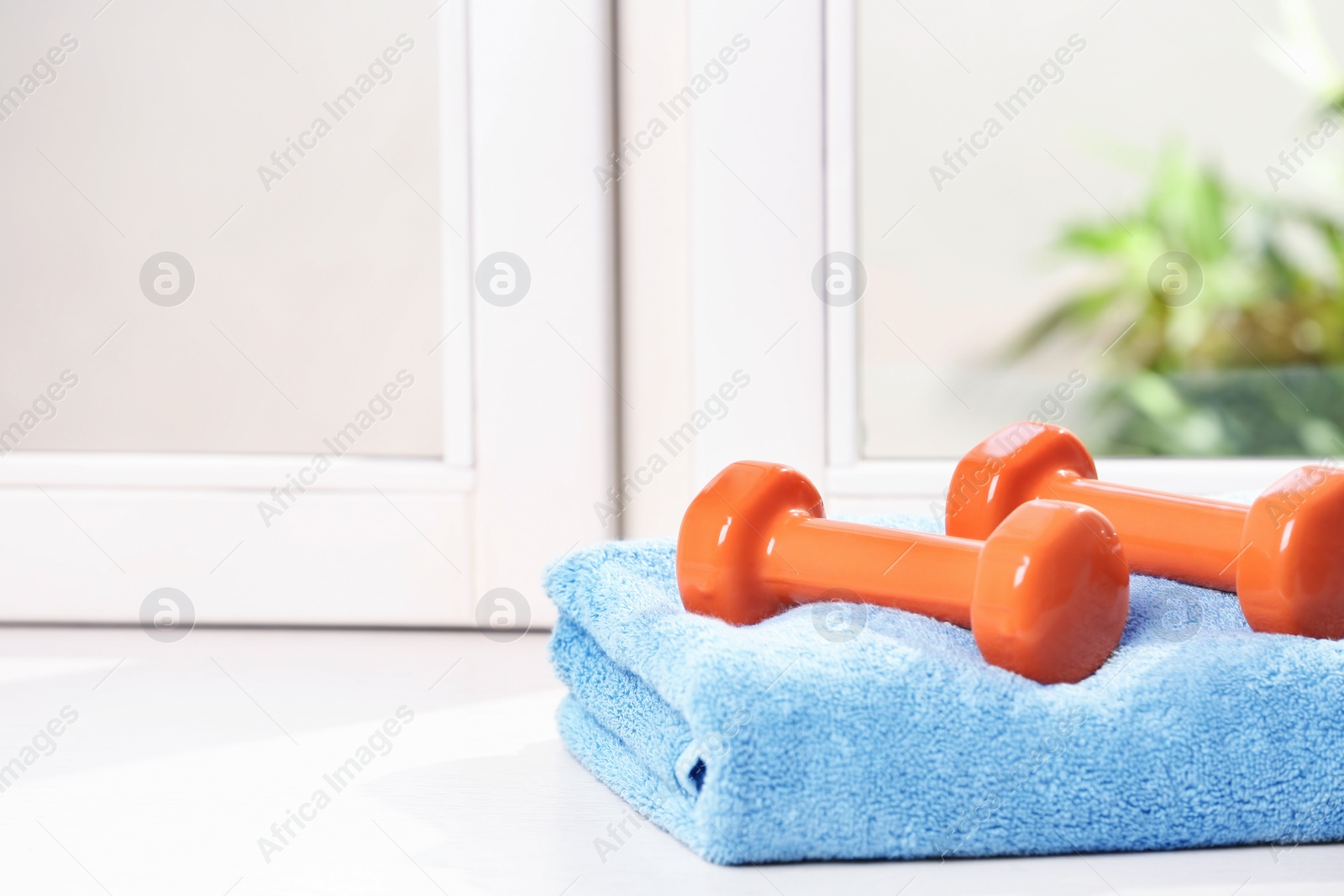 Photo of Towel with vinyl dumbbells on windowsill, space for text