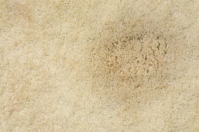 Wet spot on beige carpet as background, top view