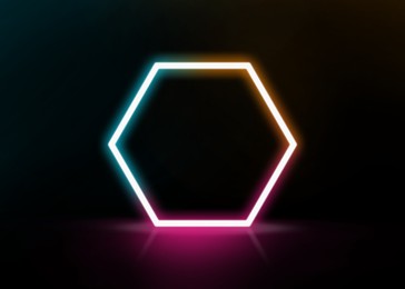 Glowing hexagonal neon frame on black background, space for text