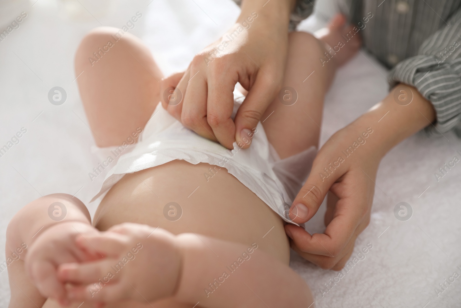 Photo of Mother changing her baby's diaper on table, closeup