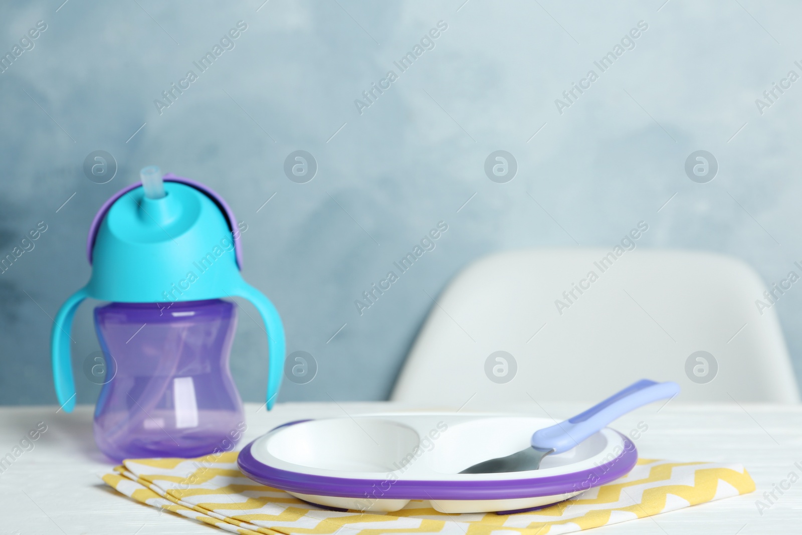 Photo of Set of plastic dishware on white table. Serving baby food