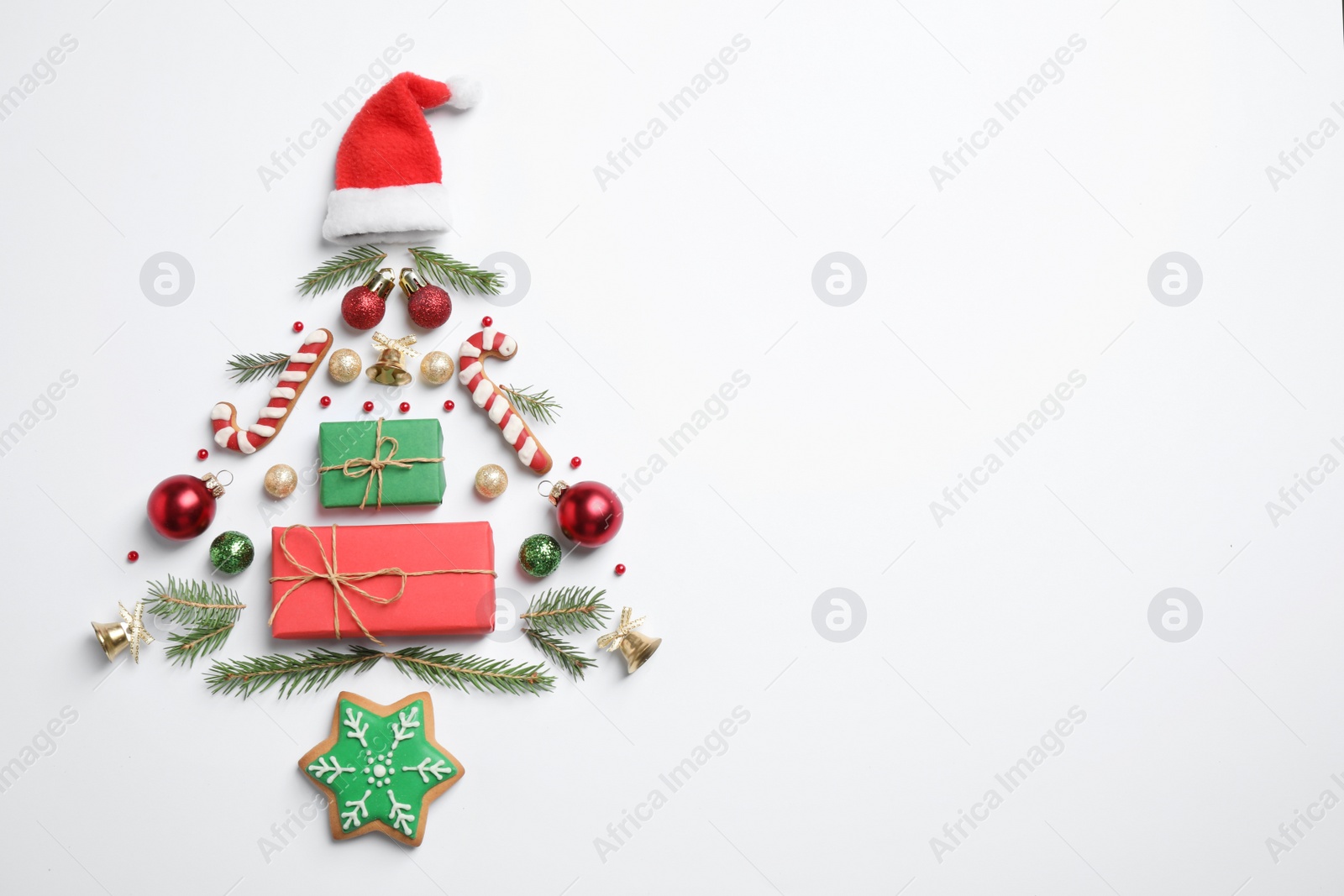 Photo of Christmas tree silhouette of fir branches and festive decoration on white background, top view