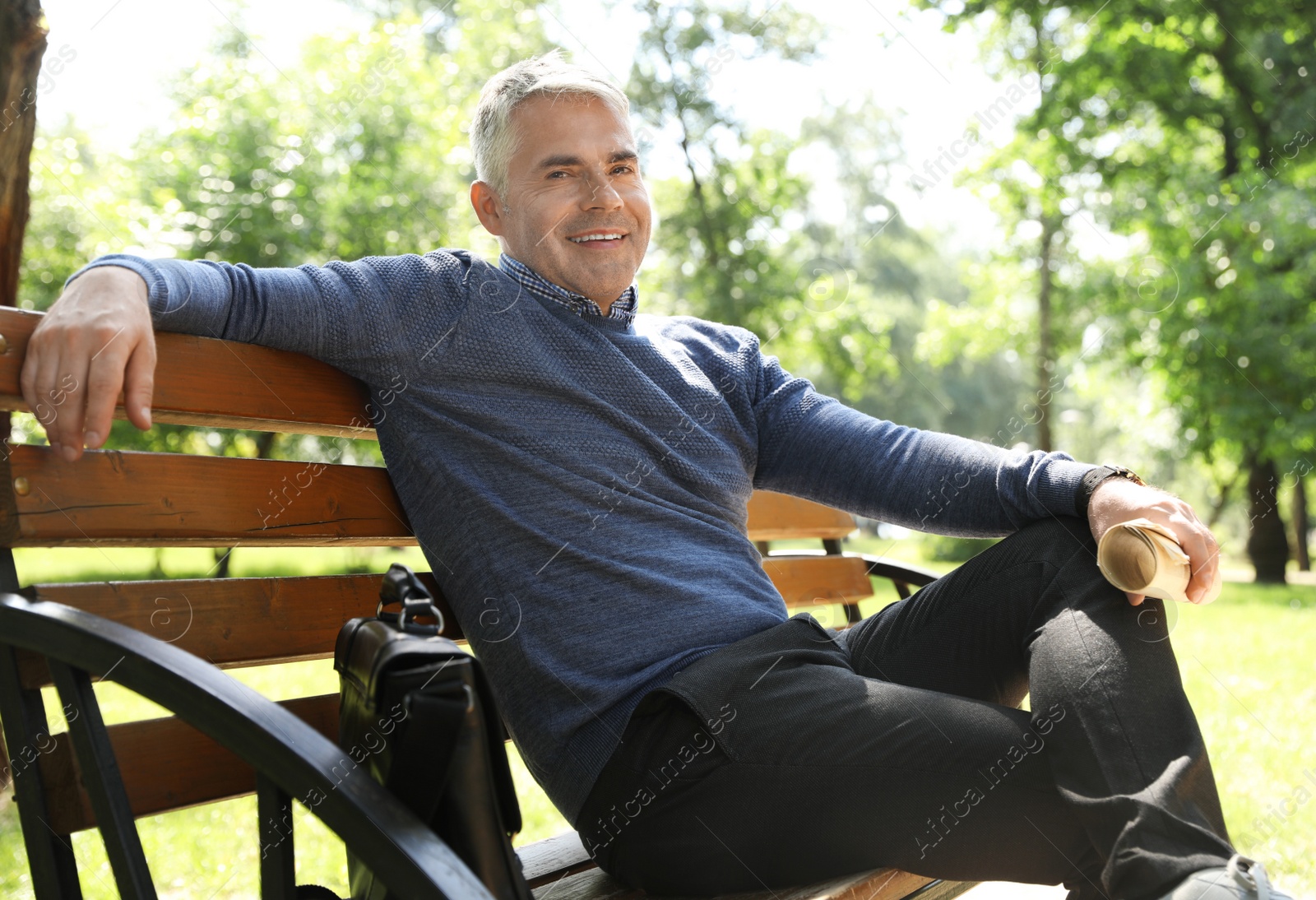 Photo of Portrait of handsome man with newspaper in park