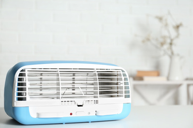 Photo of Modern air purifier on white table in room