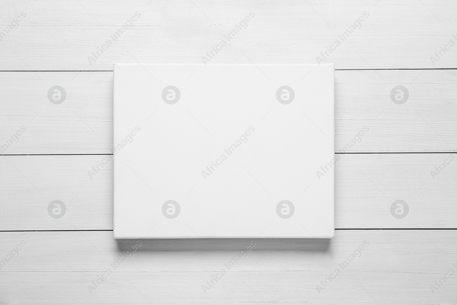 Photo of Blank canvas on white wooden background, top view. Space for design