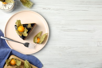 Delicious dessert decorated with physalis fruit on white wooden table, flat lay. Space for text