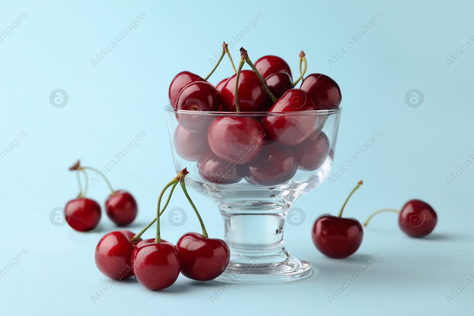 Photo of Fresh ripe cherries on light blue background