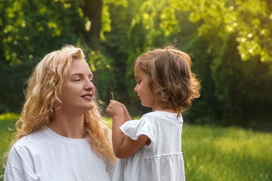 Photo of Beautiful mother with her cute daughter spending time together outdoors