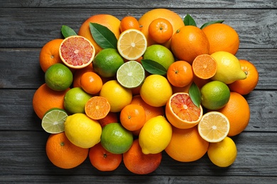 Flat lay composition with different citrus fruits on wooden background