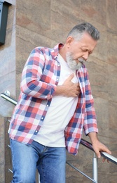 Photo of Mature man having heart attack, outdoors