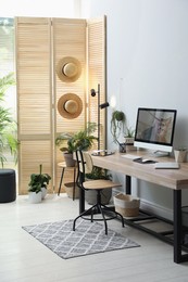 Photo of Comfortable workplace with computer in light room. Interior design