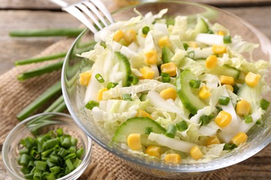 Photo of Tasty salad with Chinese cabbage, corn and cucumber in bowl on table, closeup