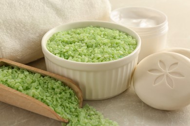 Composition with green sea salt on light grey table, closeup