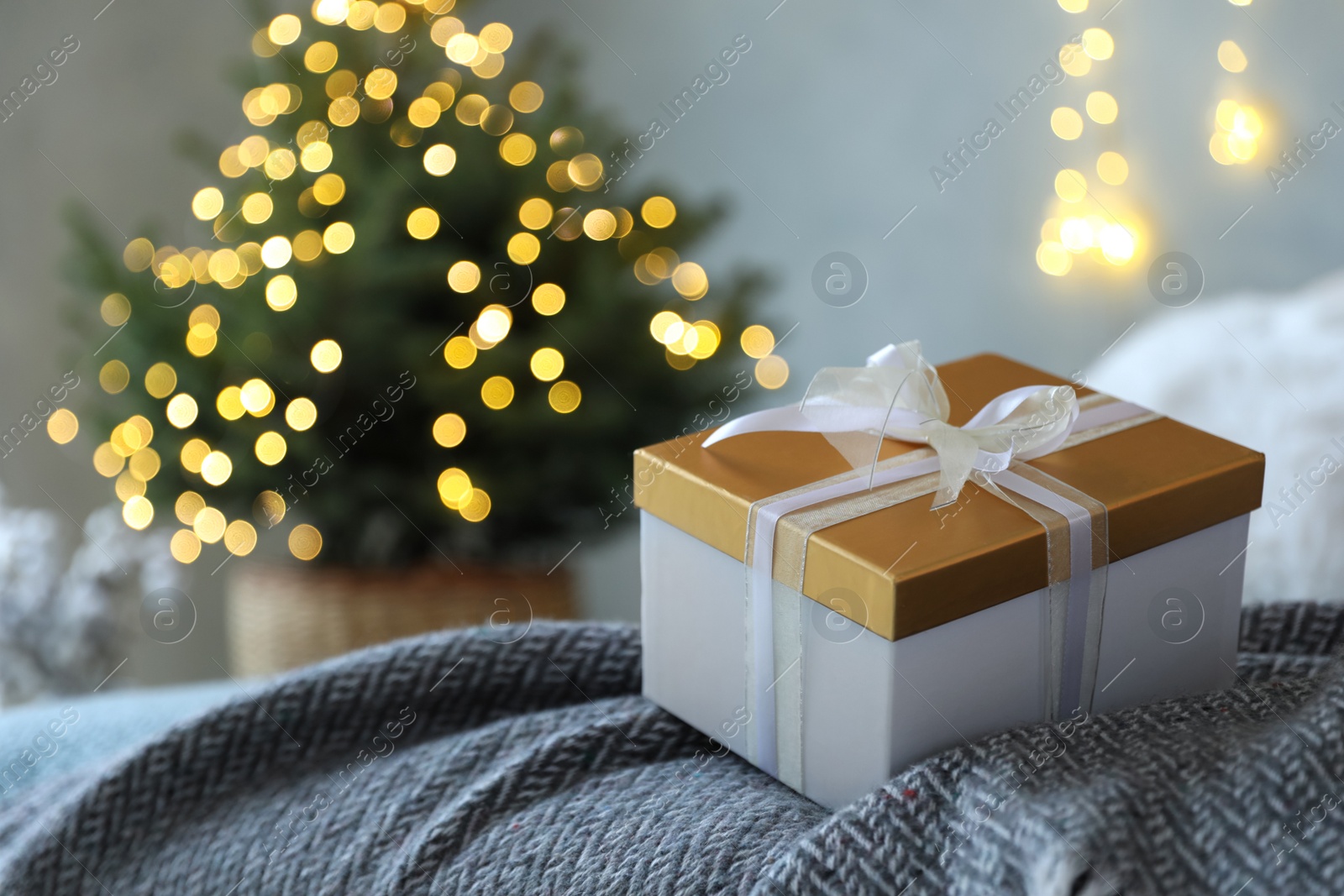 Photo of Christmas gift box on bed in festive interior