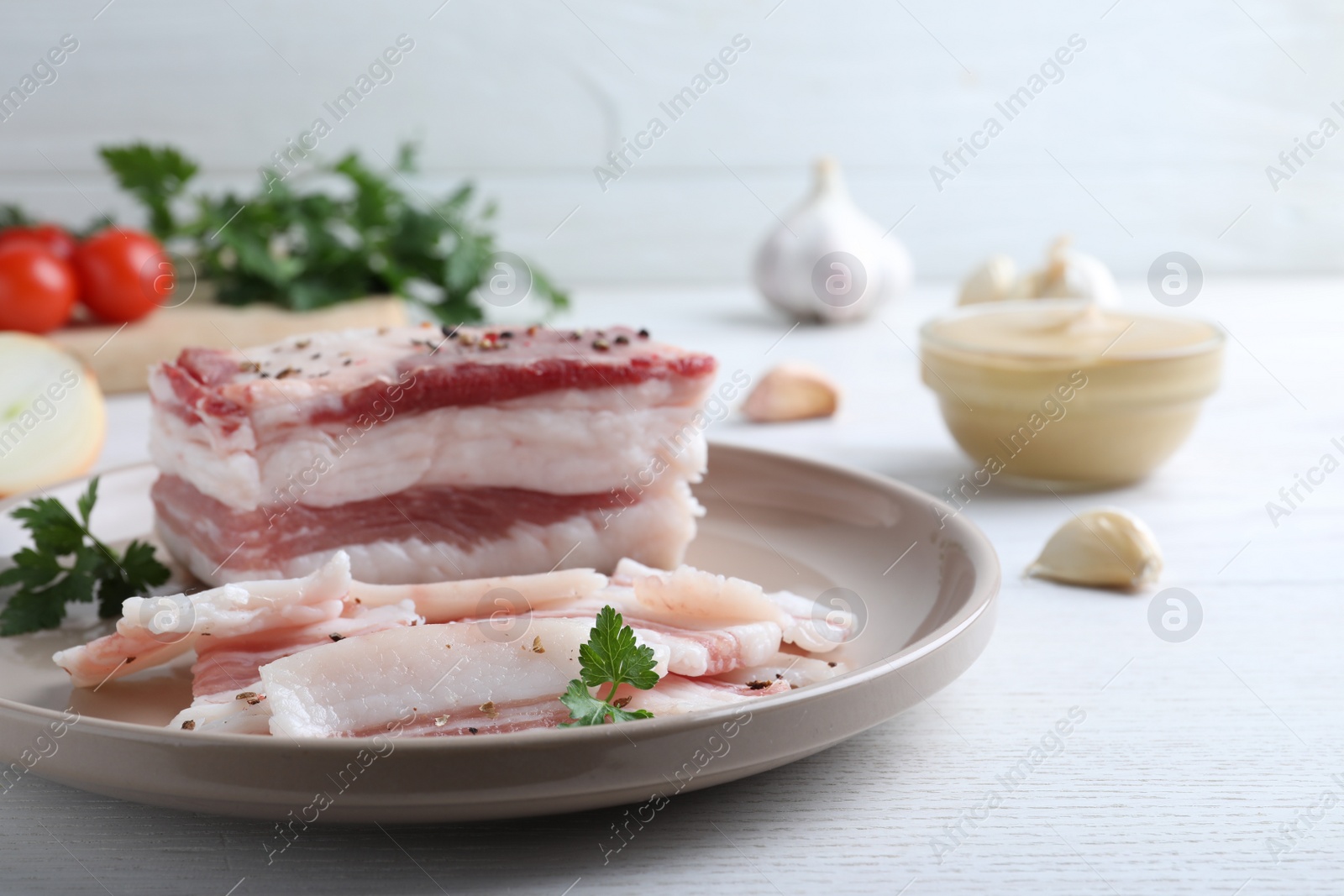 Photo of Tasty salt pork with parsley on white wooden table