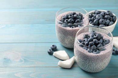 Delicious chia pudding with blueberries on light blue wooden table, space for text