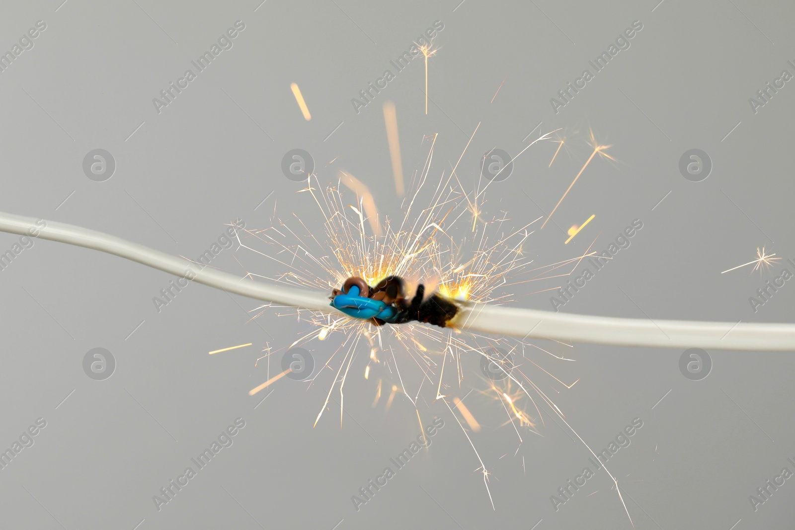 Image of Sparking electrical wire on light background, closeup