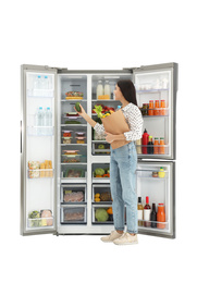 Photo of Young woman with bag of groceries near open refrigerator on white background