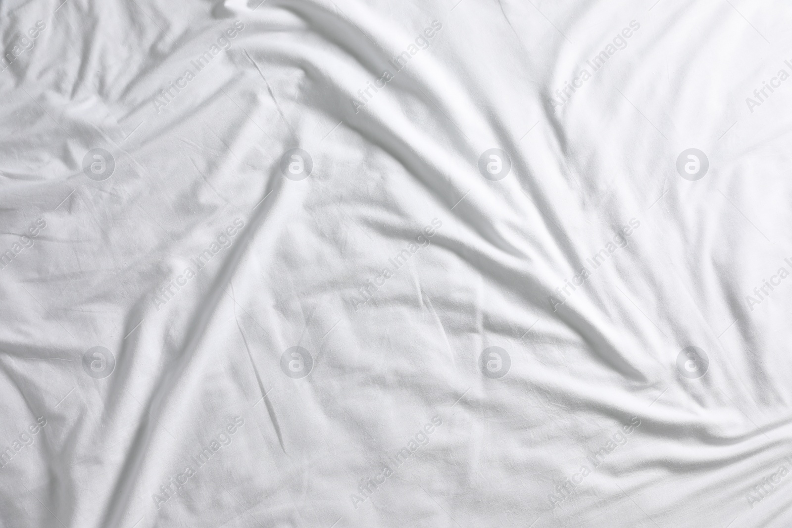 Photo of Crumpled white fabric as background, top view