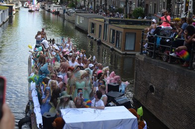 AMSTERDAM, NETHERLANDS - AUGUST 06, 2022: Many people in boat at LGBT pride parade on river