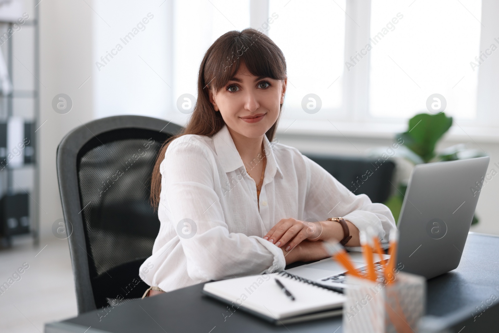 Photo of Woman watching webinar at table in office