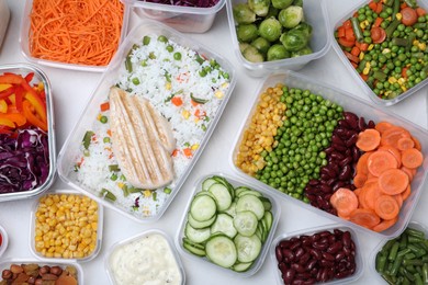 Photo of Set of containers with fresh food on white table, flat lay