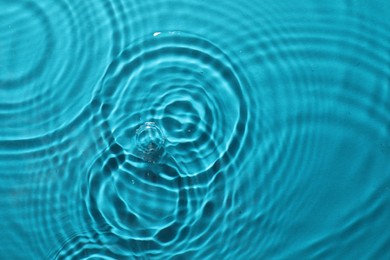 Rippled surface of clear water on light blue background, top view