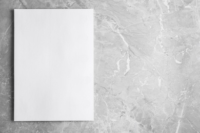 Photo of Blank paper sheet on light grey marble background, top view. Mock up for design