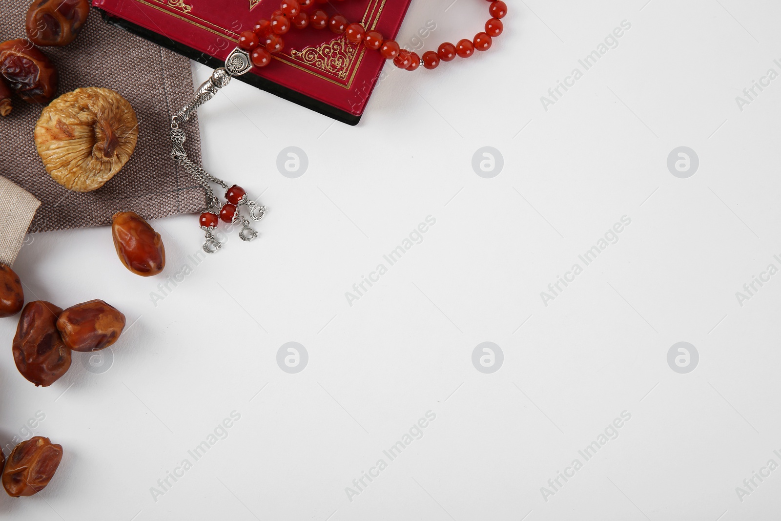 Photo of Flat lay composition with Koran, Muslim prayer beads and space for text on white background