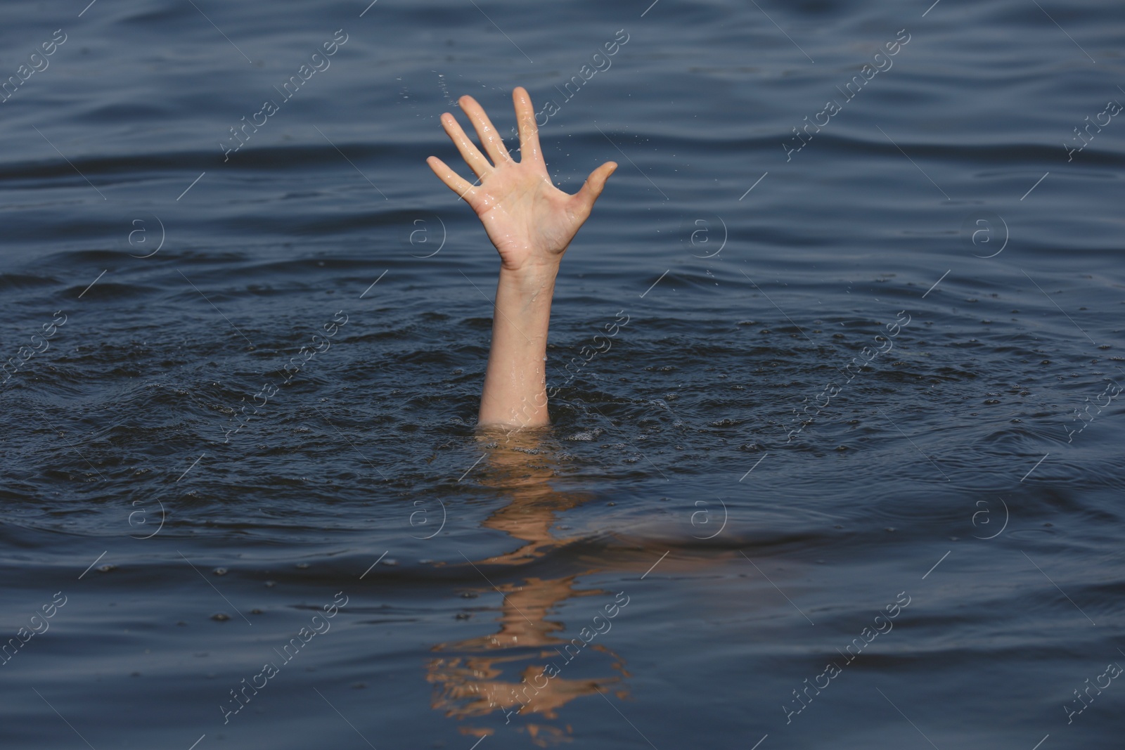 Photo of Drowning woman reaching for help in sea, closeup