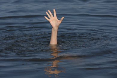 Drowning woman reaching for help in sea, closeup