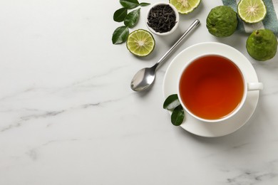 Photo of Cup of tasty bergamot tea, dry leaves and fresh fruits on white table, flat lay. Space for text