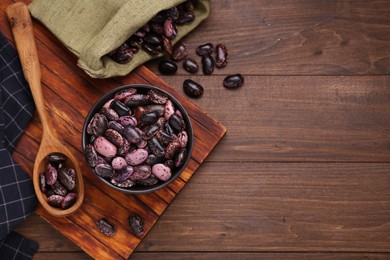 Many dry kidney beans on wooden table, flat lay. Space for text