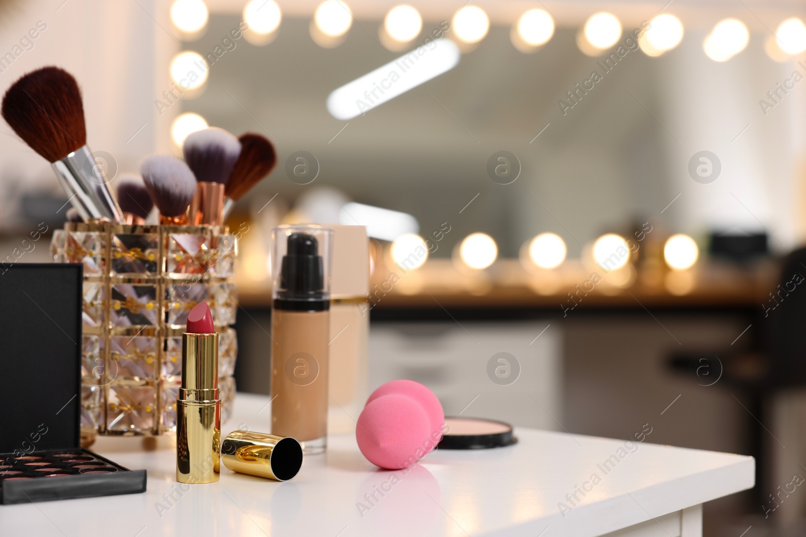 Photo of Different cosmetic products on white table in makeup room, space for text