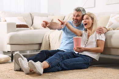 Photo of Happy affectionate couple with popcorn spending time together at home. Romantic date
