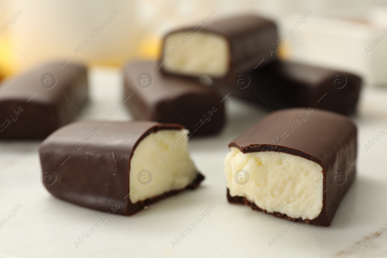 Photo of Glazed curd cheese bars on white board, closeup