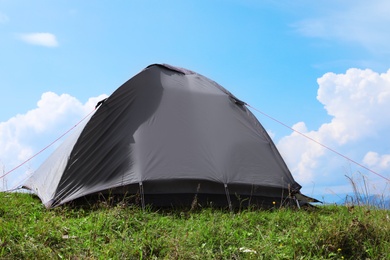 Photo of Small camping tent in mountains on sunny day