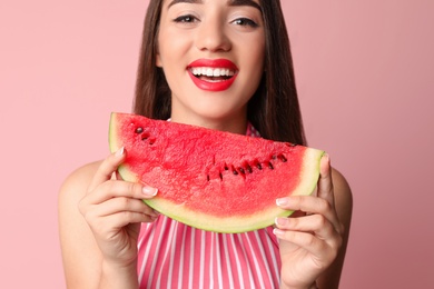 Beautiful young woman posing with watermelon on color background