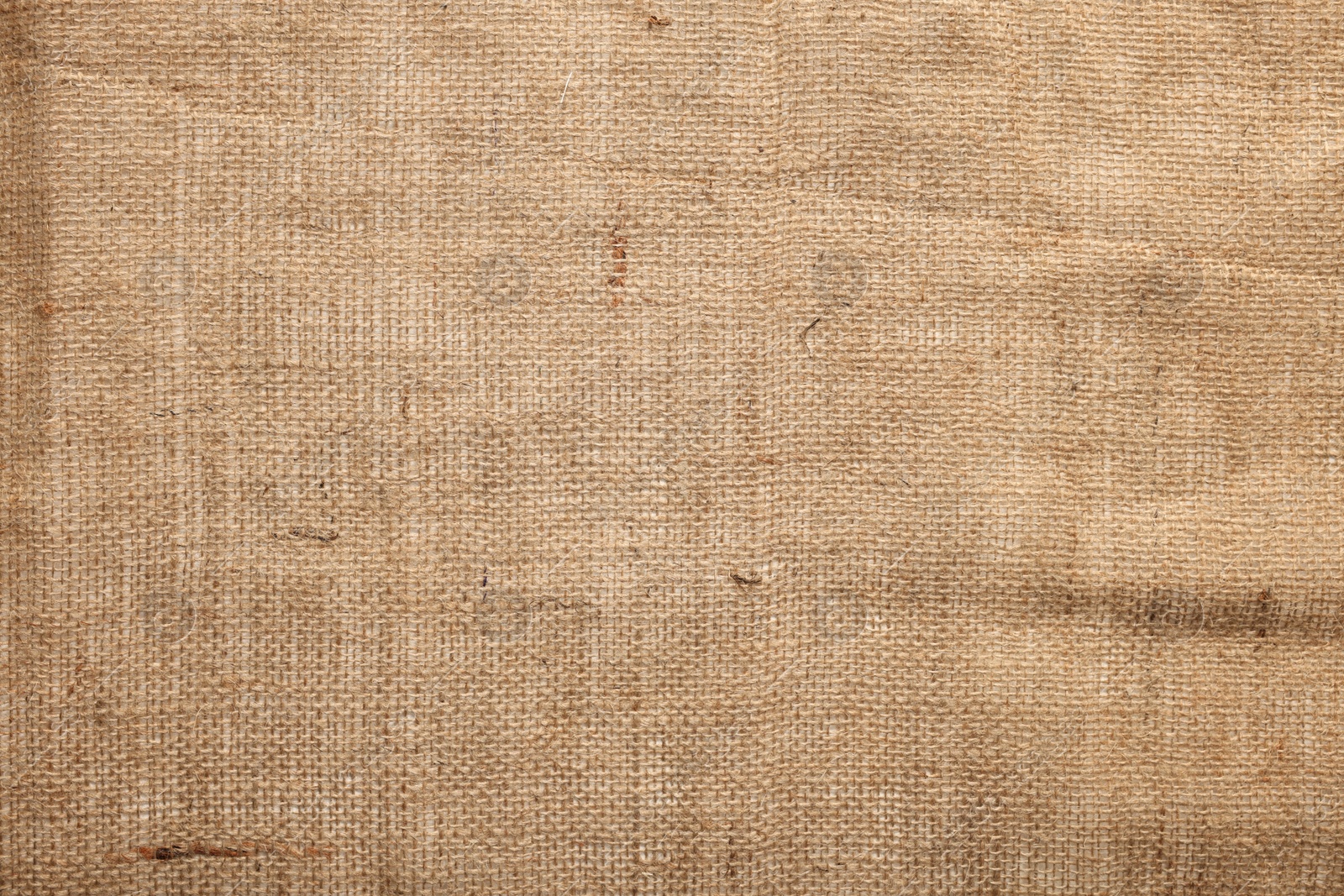 Photo of Texture of natural burlap fabric as background, top view