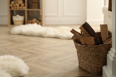 Basket with firewood on floor in room