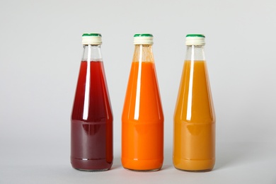 Bottles with different drinks on color background